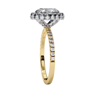 Side profile view of a yellow gold oval cut diamond double halo engagement ring showing the elevated cathedral gallery.