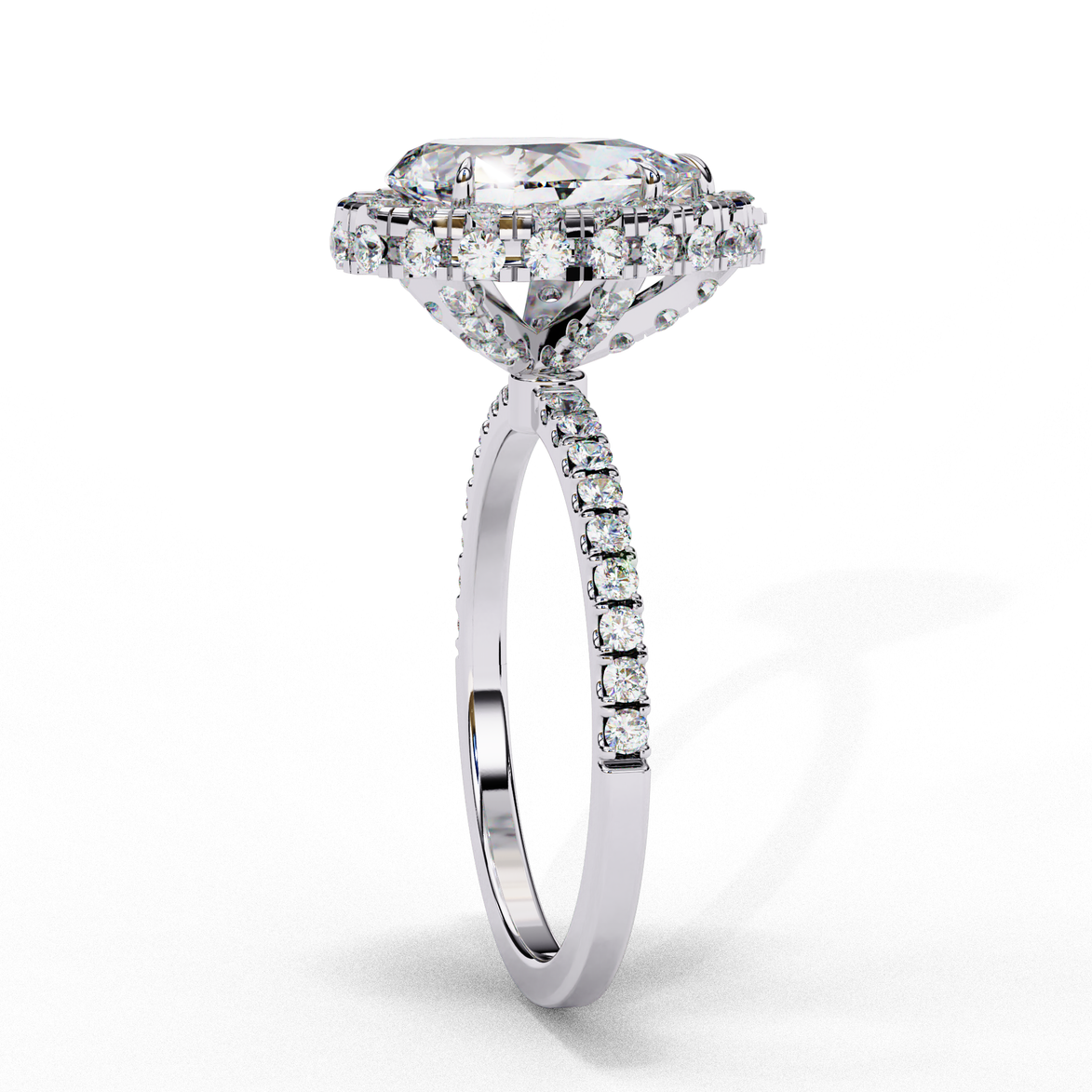Side profile view of a white gold pear shaped diamond halo engagement ring showing the elevated cathedral gallery.