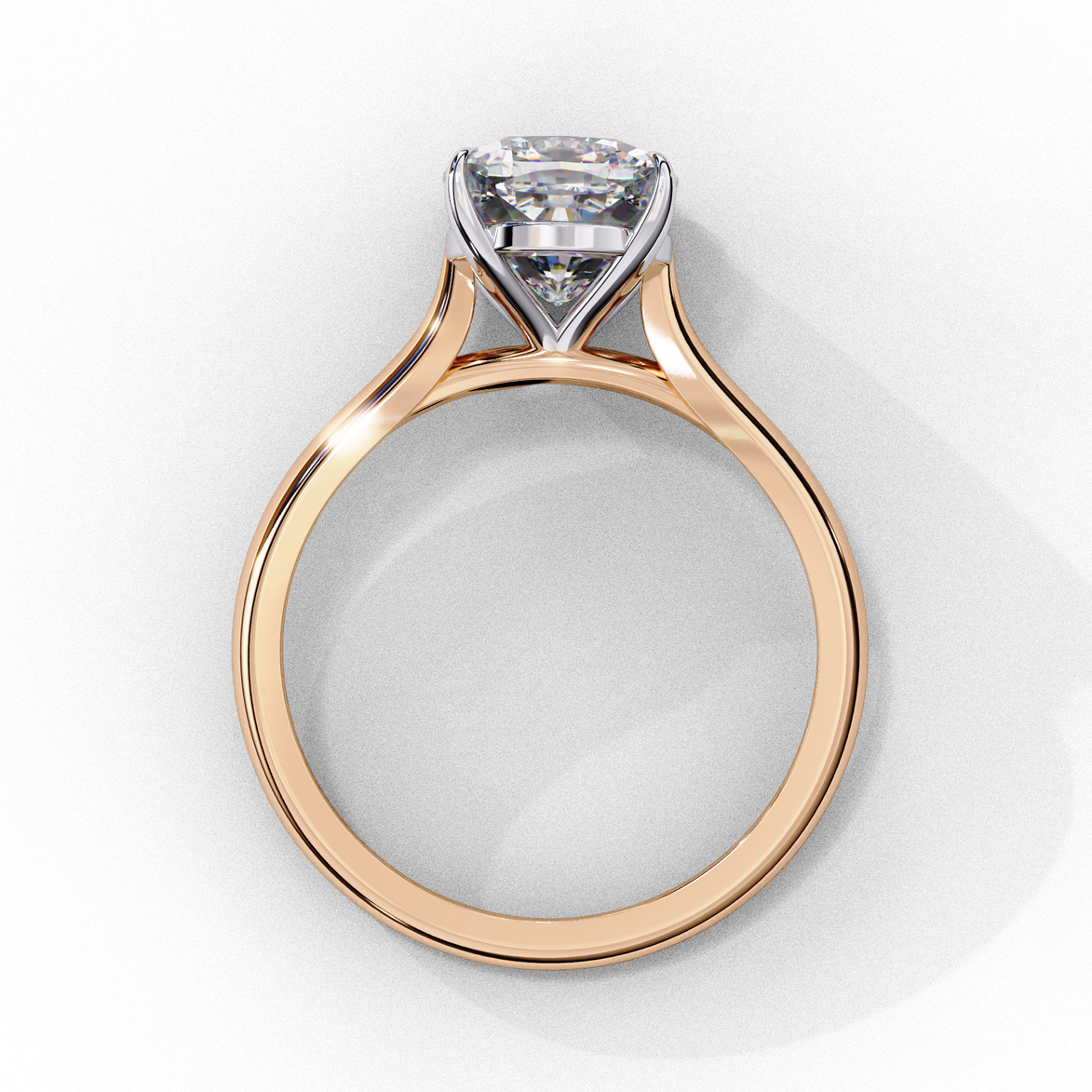 Side profile view of a rose gold round brilliant cut diamond solitaire ring showing the classic four-prong head layout.