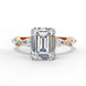 Front view of a rose gold emerald cut diamond engagement ring with alternating marquise and round accent diamonds.