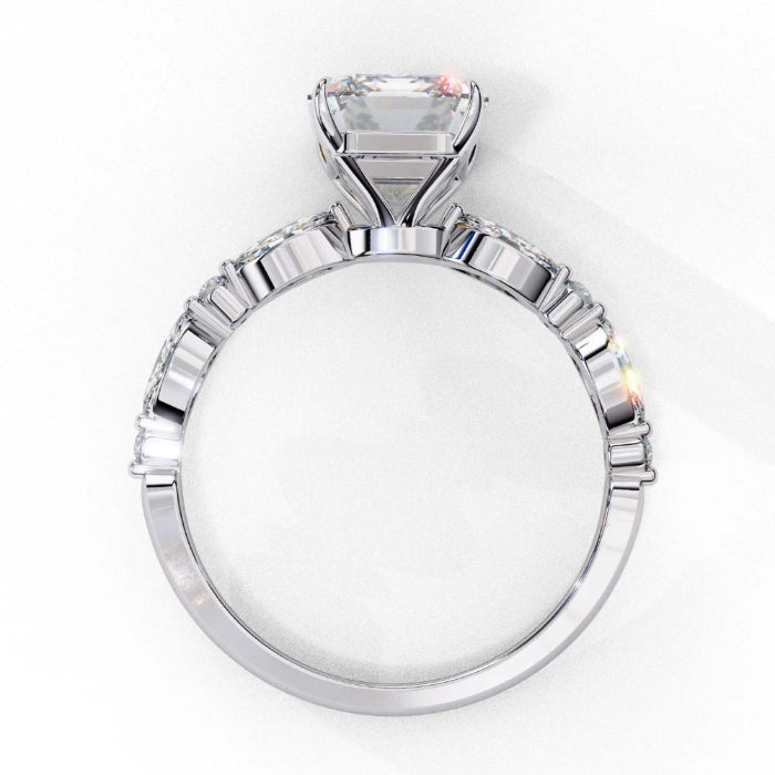 Side profile view of a white gold emerald cut diamond engagement ring showcasing the classic four-prong head structure.