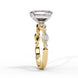 Side profile view of a yellow gold emerald cut diamond engagement ring showing the elegant cathedral gallery profile.