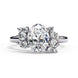 Front view of a white gold oval cut diamond engagement ring featuring symmetrical floral cluster side stones.