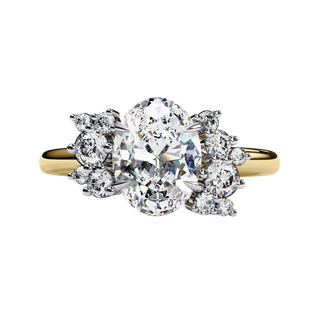Front view of a yellow gold oval cut diamond engagement ring featuring symmetrical floral cluster side stones.