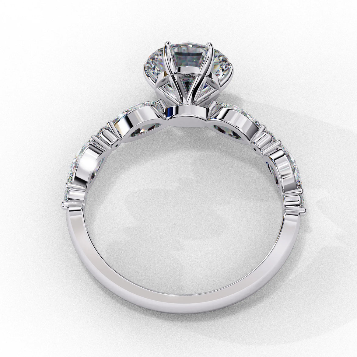 Side profile view of a white gold round brilliant cut diamond engagement ring highlighting the open under-gallery construction.
