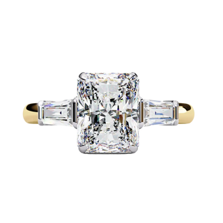 Yellow gold radiant cut diamond ring with tapered baguette side stones, front view.