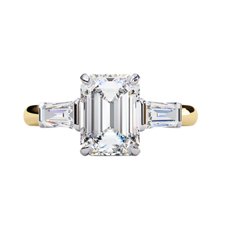 Yellow gold emerald cut diamond ring with tapered baguette side stones, front view.