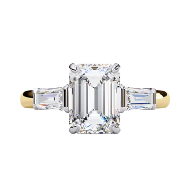 Yellow gold emerald cut diamond ring with tapered baguette side stones, front view.