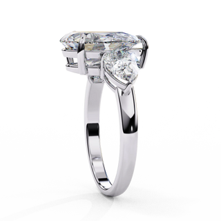 Side profile view of a white gold pear-cut diamond three-stone ring standing vertically.