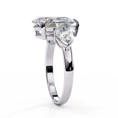 Side profile view of a white gold pear-cut diamond three-stone ring standing vertically.