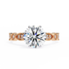Rose gold ring with a large diamond and smaller diamonds on the band against a white background