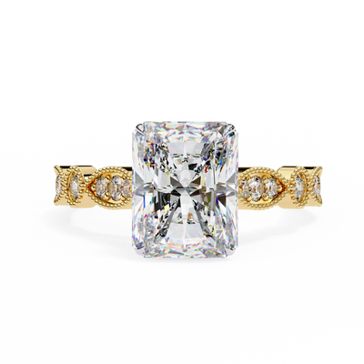 Gold ring with a large diamond and smaller diamonds on the band against a white background
