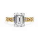 Gold ring with a large emerald-cut diamond and smaller diamonds on the band against a white background