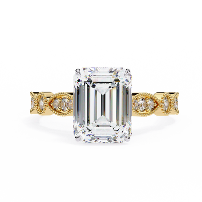 Gold ring with a large emerald-cut diamond and smaller diamonds on the band against a white background