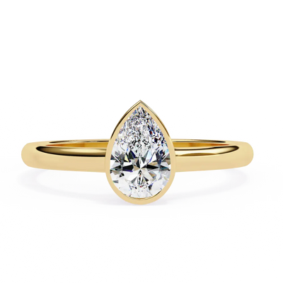 Gold ring with a pear-shaped diamond on a white background