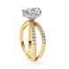 Gold ring with a large diamond and smaller diamonds on the band against a white background