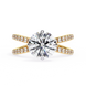 Gold ring with a large diamond and smaller diamonds on the band against a white background