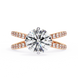 Gold ring with a large diamond and smaller diamonds on the band against a white background