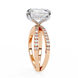 Rose gold ring with a large diamond and smaller diamonds on the band against a white background