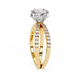 Gold ring with a large diamond and smaller diamonds on the band against a white background