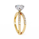 Gold ring with a large diamond and smaller diamonds on the band against a white background