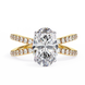 Gold ring with a large diamond and smaller diamonds on the band against a white background