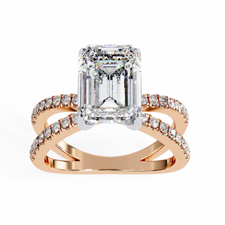 Rose gold ring with emerald-cut diamond and smaller diamonds on a white background