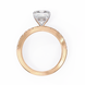Rose gold ring with a large diamond and smaller diamonds on the band against a white background