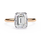Rose gold ring with a large emerald-cut diamond on a white background