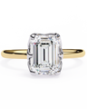 Gold ring with a large emerald-cut diamond on a white background