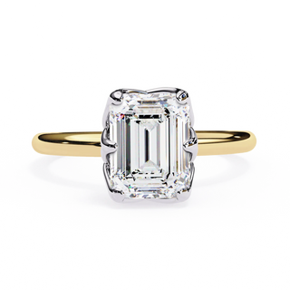 Gold ring with a large emerald-cut diamond on a white background