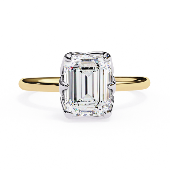 Gold ring with a large emerald-cut diamond on a white background