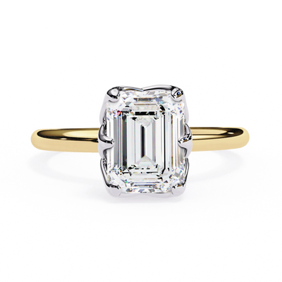 Gold ring with a large emerald-cut diamond on a white background