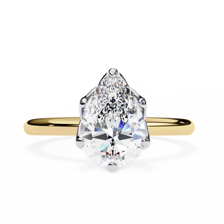 Gold ring with a pear-shaped diamond on a white background