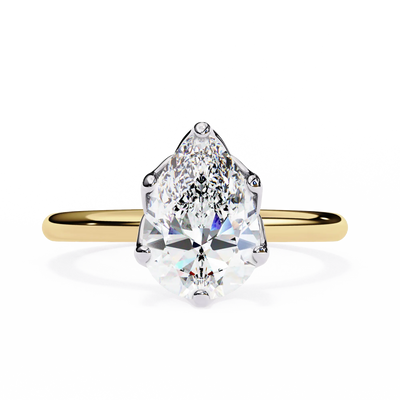 Gold ring with a pear-shaped diamond on a white background