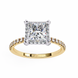 Gold ring with a large diamond and smaller diamonds on the band against a white background