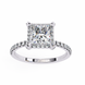 Diamond ring with a prominent central stone and smaller stones on the band against a white background