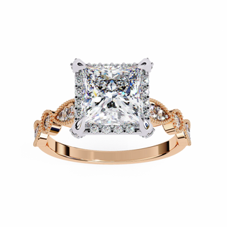 Gold ring with a large diamond and smaller diamonds on the band against a white background