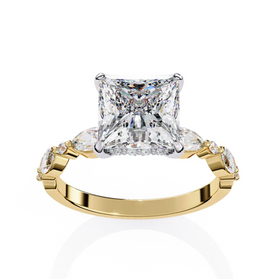 Gold ring with a large diamond and smaller diamonds on the sides against a white background