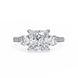 Diamond ring with a central princess-cut diamond and smaller round diamonds on a white background
