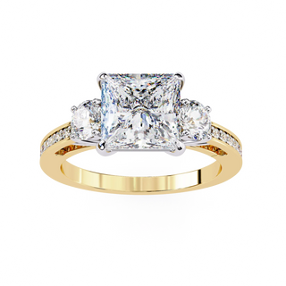 Gold ring with a central square-cut diamond and two smaller diamonds on a white background