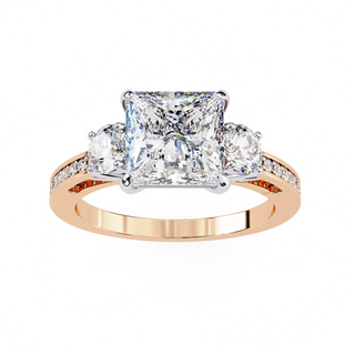Rose gold ring with a large central diamond and smaller diamonds on the sides against a white background