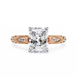 Rose gold ring with a large diamond and smaller diamonds on the band against a white background