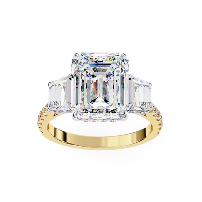 Gold ring with a large diamond and smaller emerald-cut diamonds on a white background