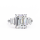 Diamond ring with emerald-cut center stone on a white background