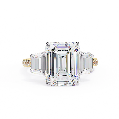 Diamond ring with emerald-cut center stone on a white background
