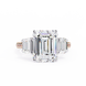 Diamond ring with emerald-cut center stone on a white background
