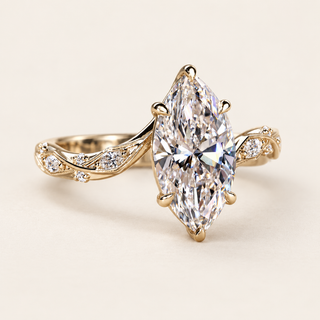 Marquise cut lab grown diamond engagement ring with 2.00 ct center, protective pointed-end prongs, leaf-like openwork shoulders and marquise and round diamond accents in yellow gold.