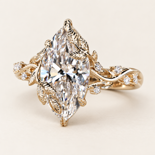 Marquise cut lab grown diamond engagement ring with 3 ct center, leaf-shaped protective prongs, sculpted gold vines and round diamond accents in yellow gold.