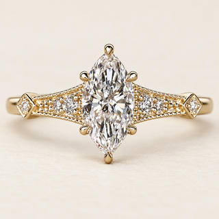 Marquise cut lab grown diamond cathedral engagement ring with a prong-set center, pavé diamond shoulders, Art Deco milgrain and geometric yellow gold detailing.